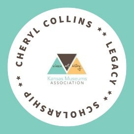 A white circle on a teal background contains the words "Cheryl Collins Legacy Scholarship" in dark brown around the perimeter with the KMA logo in the middle.