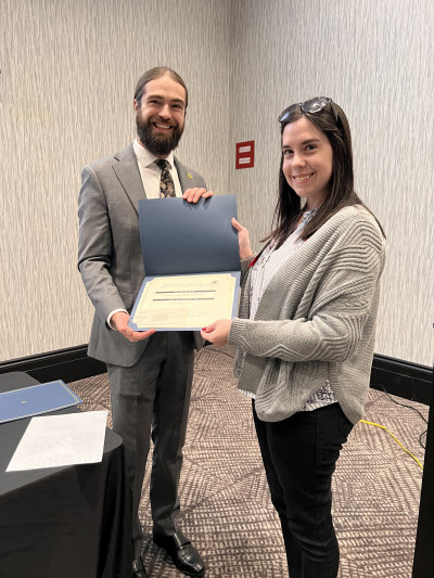 KMA Grant Committee member Trae Johnson, left, hands a grant certificate for the Geary County Historical Society to Lisa Caitlin Highsmith, right.